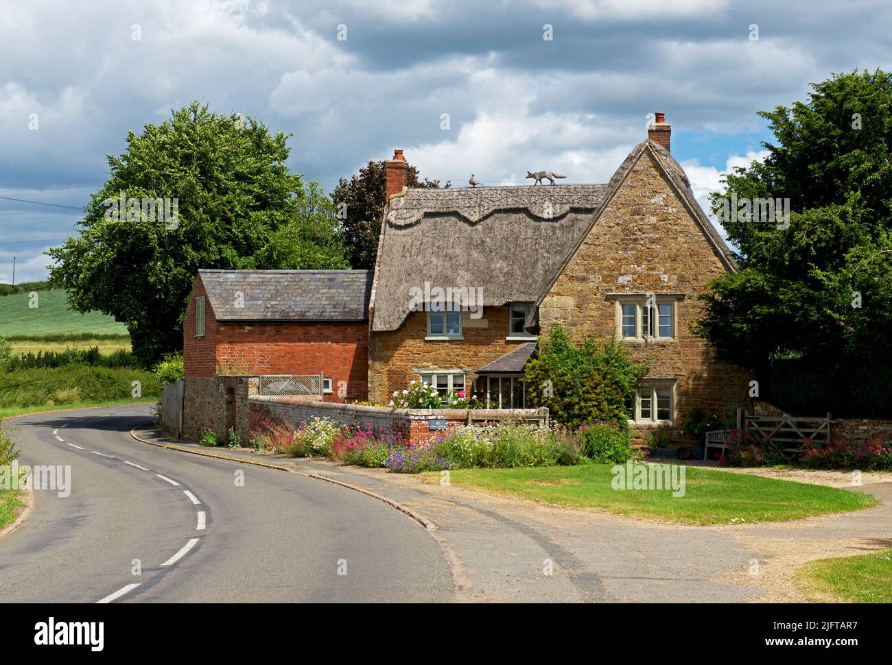 Casa de campo con techo de paja en el pueblo de Sutton Bassett, Northampton, Inglaterra Reino Unido Foto de stock
