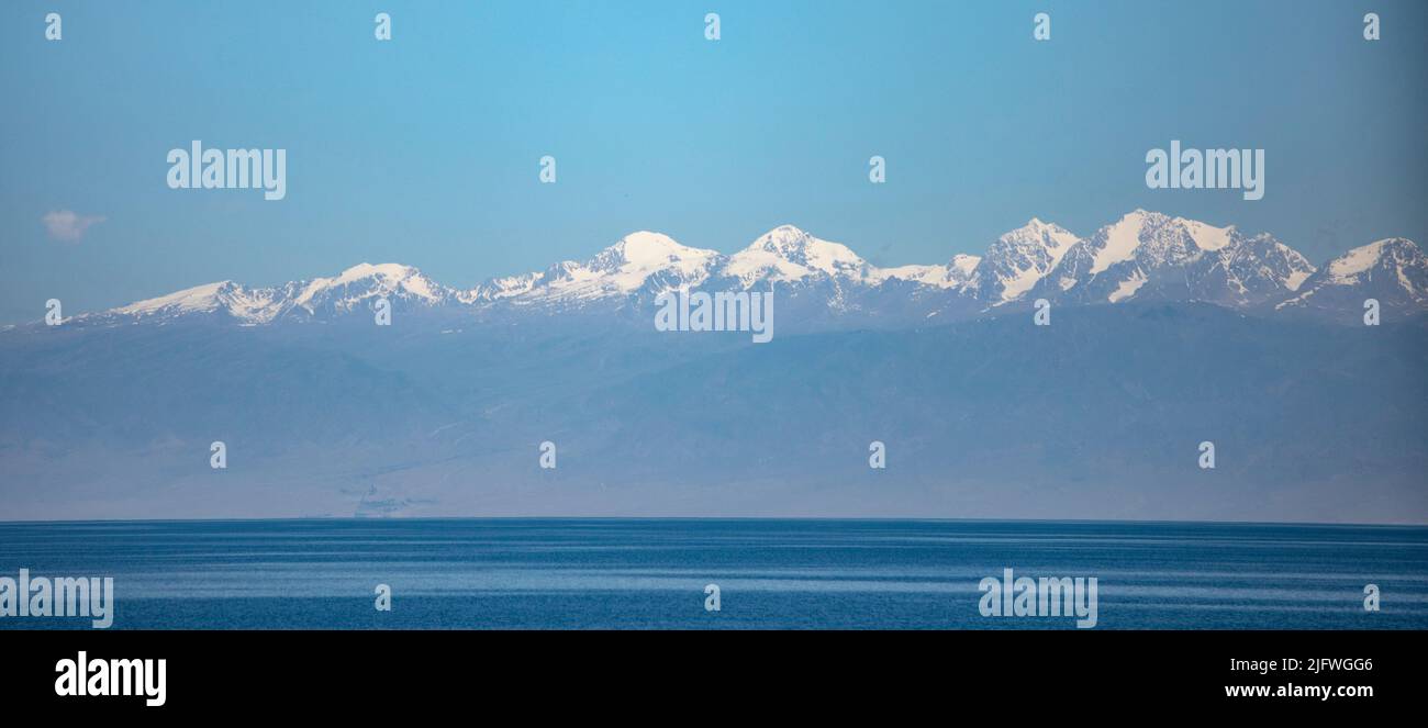 Los picos nevados de las montañas Tian Shan de Kirguistán sobre el lago Issyk-Kul Foto de stock