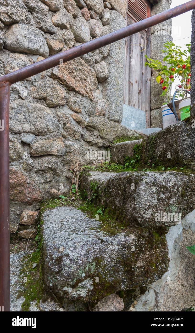 Escaleras de granito musgo que conducen a la puerta principal de una antigua casa tradicional en un pueblo (Sao Payo) en Serra da Estrela, Portugal. Foto de stock