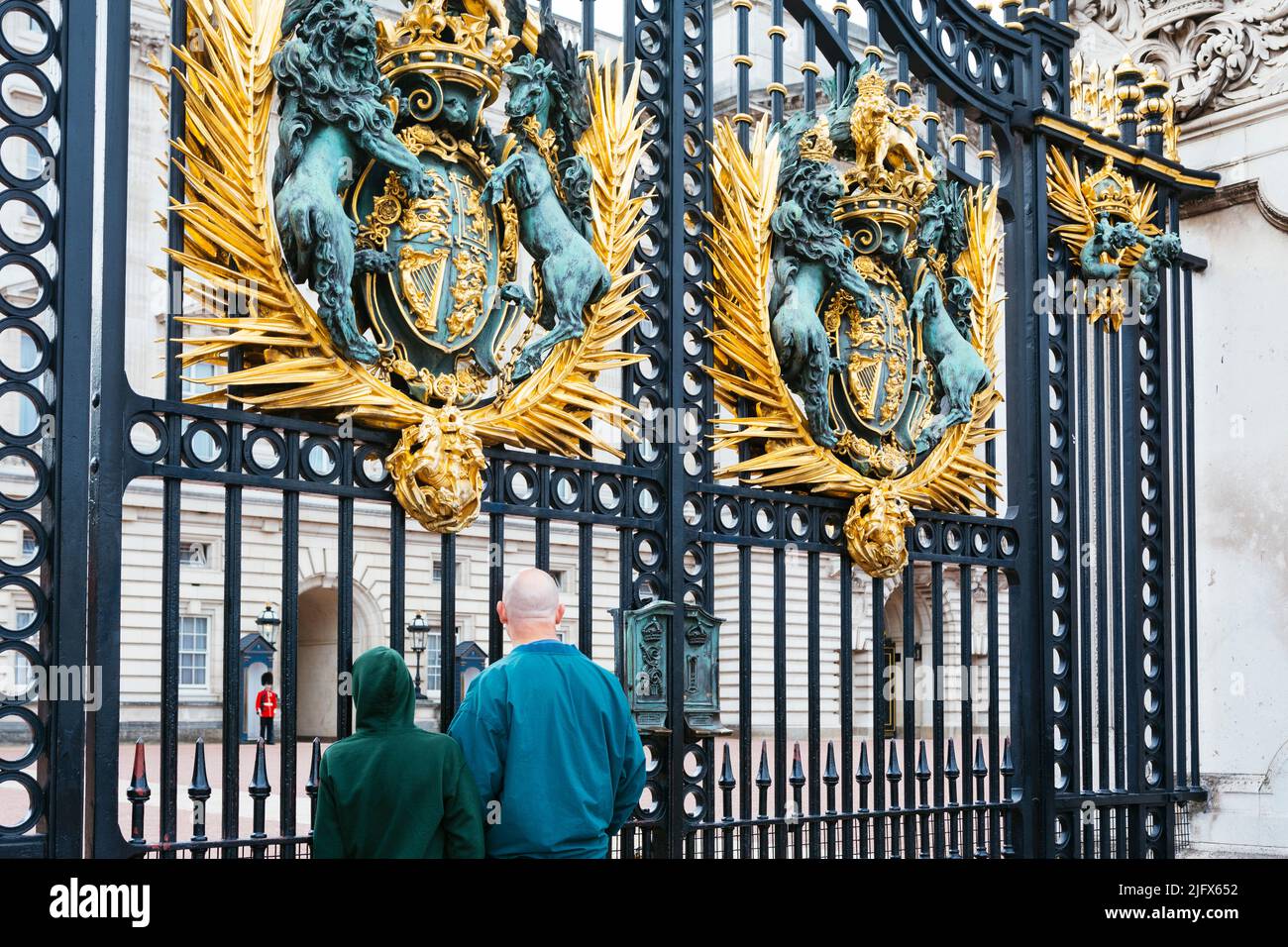 Puertas de hierro que rodean el Palacio de Buckingham. Puerta del Real Escudo de Armas del Palacio de Buckingham. Escudo Real de Armas, un León, que simboliza Inglaterra y Unico Foto de stock