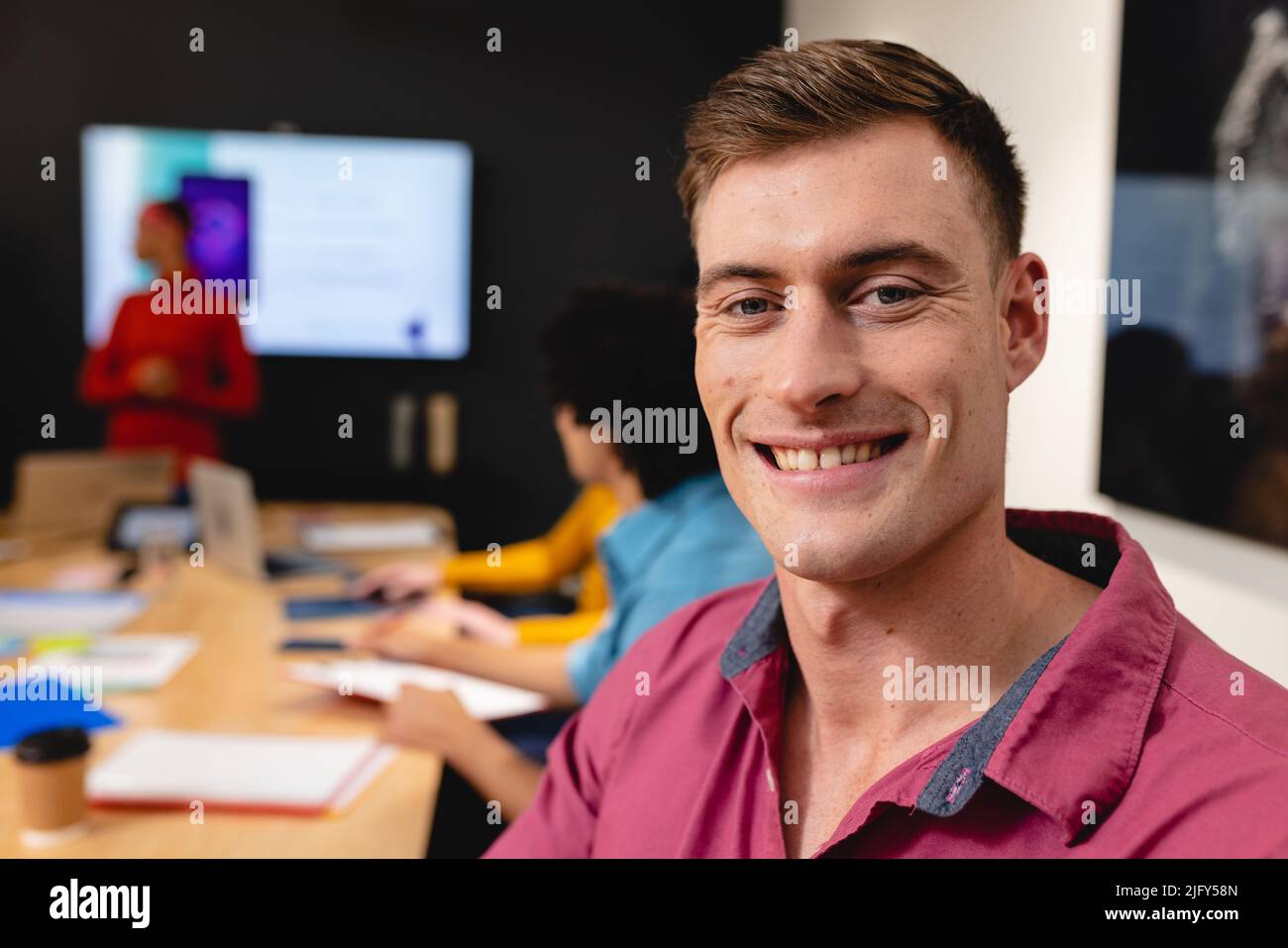 Retrato de un sonriente desarrollador de aplicaciones caucásicas en la sala de juntas de la oficina Foto de stock