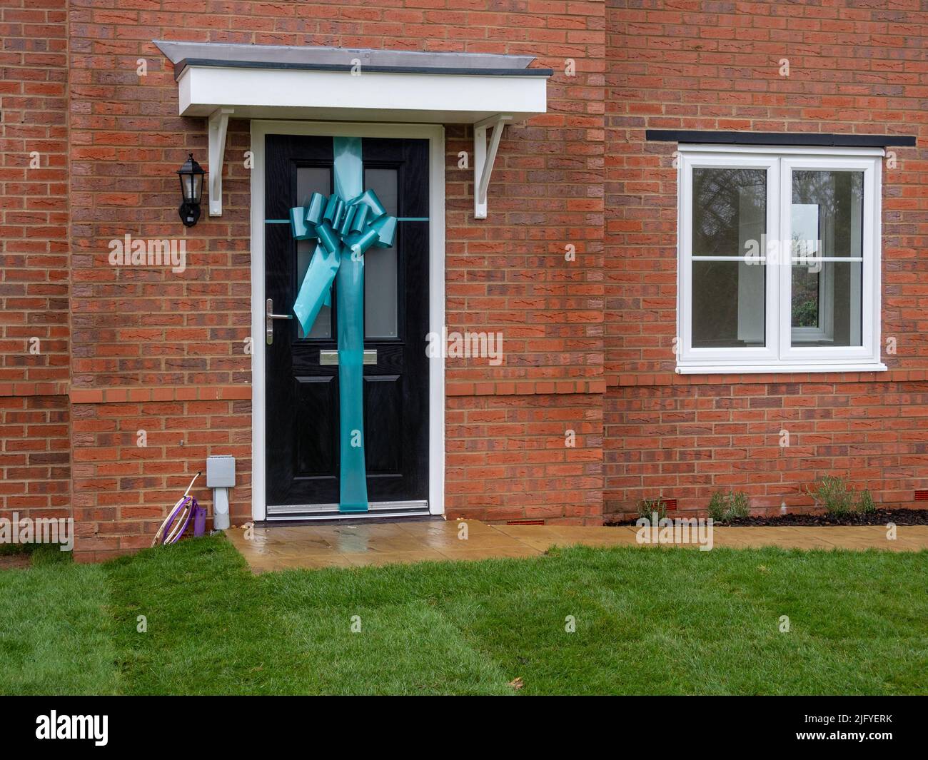 Casa de nueva construcción con una cinta alrededor de la puerta principal para dar la bienvenida al comprador, Tilia Homes, Northampton, Reino Unido Foto de stock