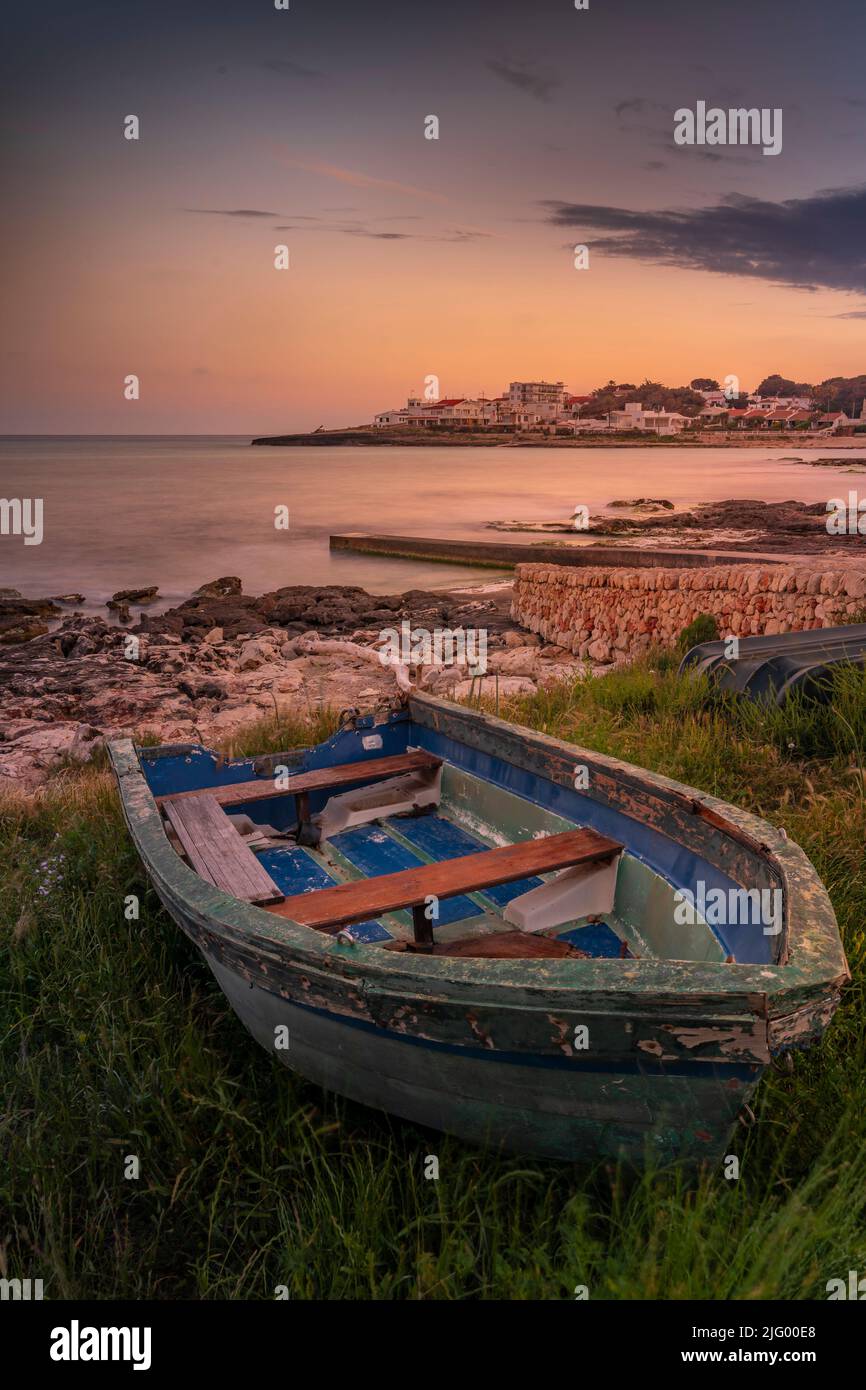 Vista de Playa Punta Prima y bote a remo al atardecer, Punta Prima, Menorca, Islas Baleares, España, Mediterráneo, Europa Foto de stock