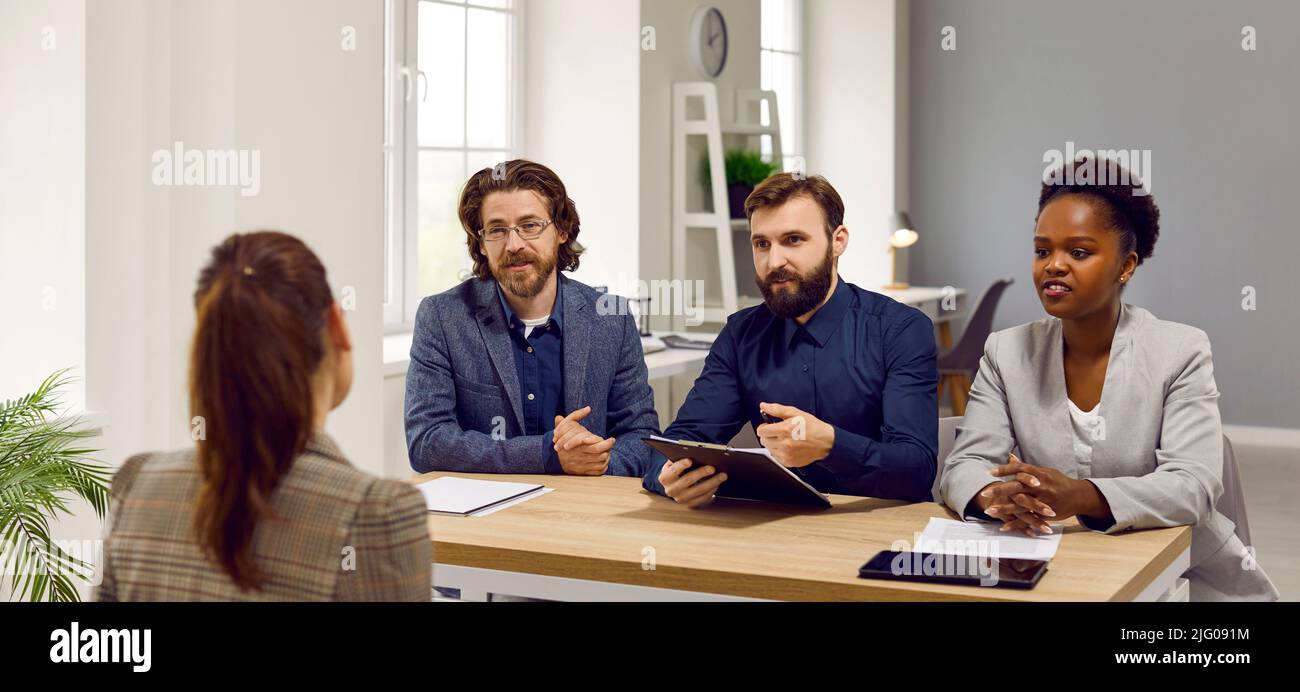 Grupo diverso de directores de RR. HH. Sentados en el escritorio de la oficina y hablando con el candidato al trabajo Foto de stock
