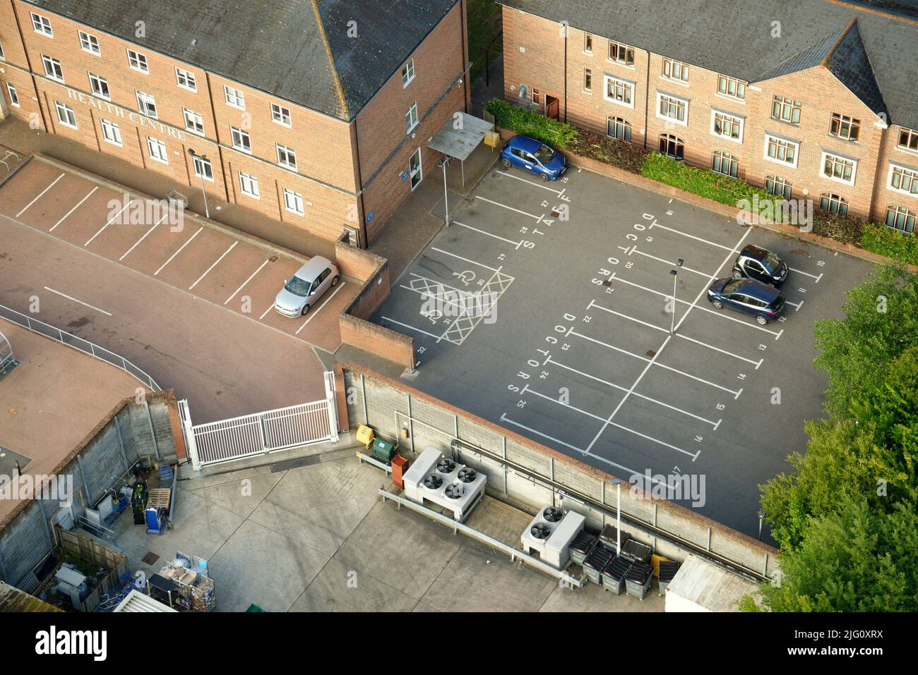 Un centro de salud inglés con un aparcamiento casi vacío. Sólo unos pocos coches aparcados. Foto de stock