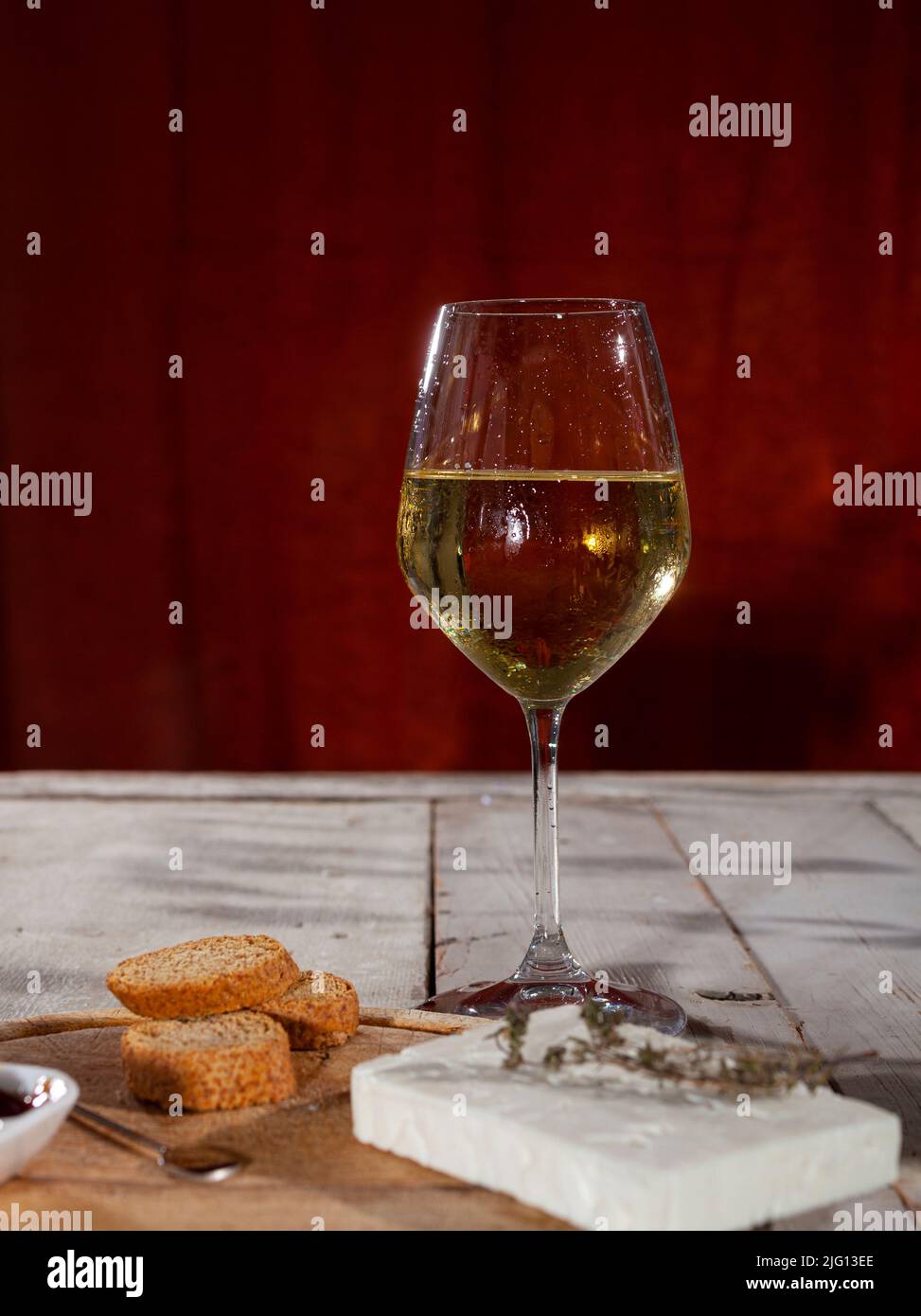 Delicioso aperitivo con tabla de queso servido con vino blanco fresco Foto de stock