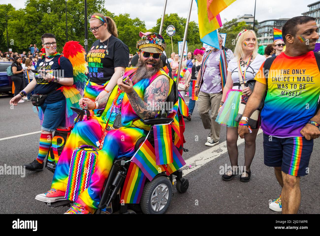 Sonriendo hombre discapacitado vestido en su silla de ruedas en Pride en Londres Foto de stock