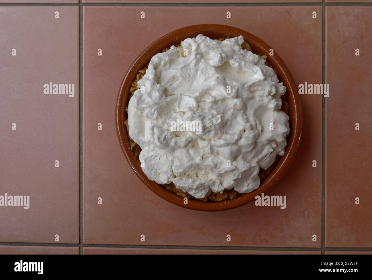 Esponjosas cremas batidas remata un pastel de banoffice Foto de stock