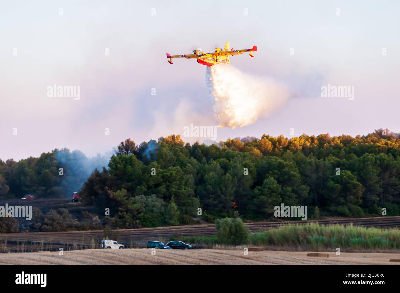 Canadaire tratando de apagar un incendio en la garriga en verano en Occitanie, Francia Foto de stock