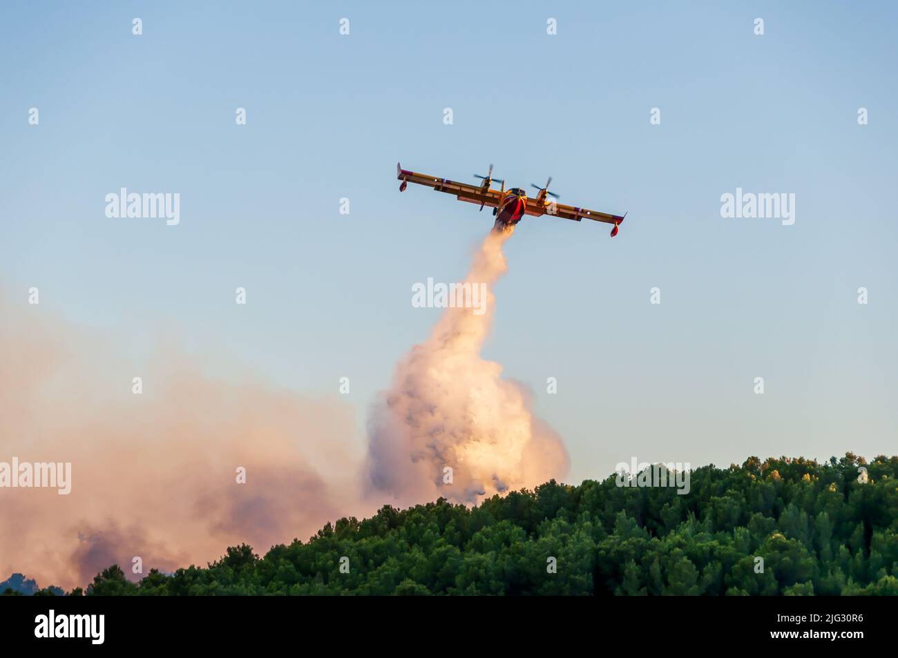 Canadaire tratando de apagar un incendio en la garriga en verano en Occitanie, Francia Foto de stock