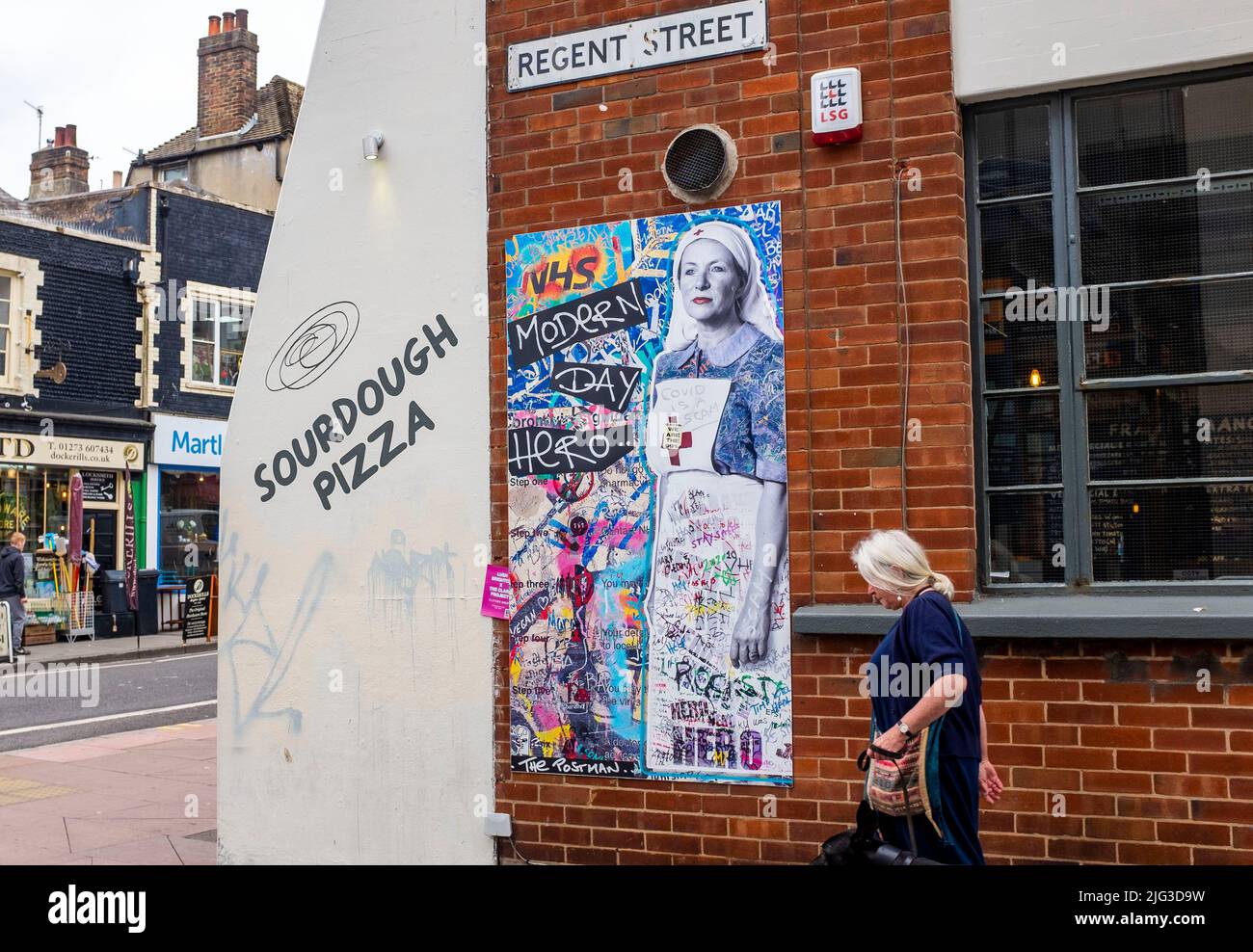 Un mural del Postman que representa a una enfermera del NHS con el título 'Modern Day Hero' en la esquina de Regent Street y Church Road en Brighton, Sussex , Inglaterra , Reino Unido - El Postman Art es un dúo de arte callejero con sede en Brighton que ilumina lugares públicos locales e internacionales Foto de stock