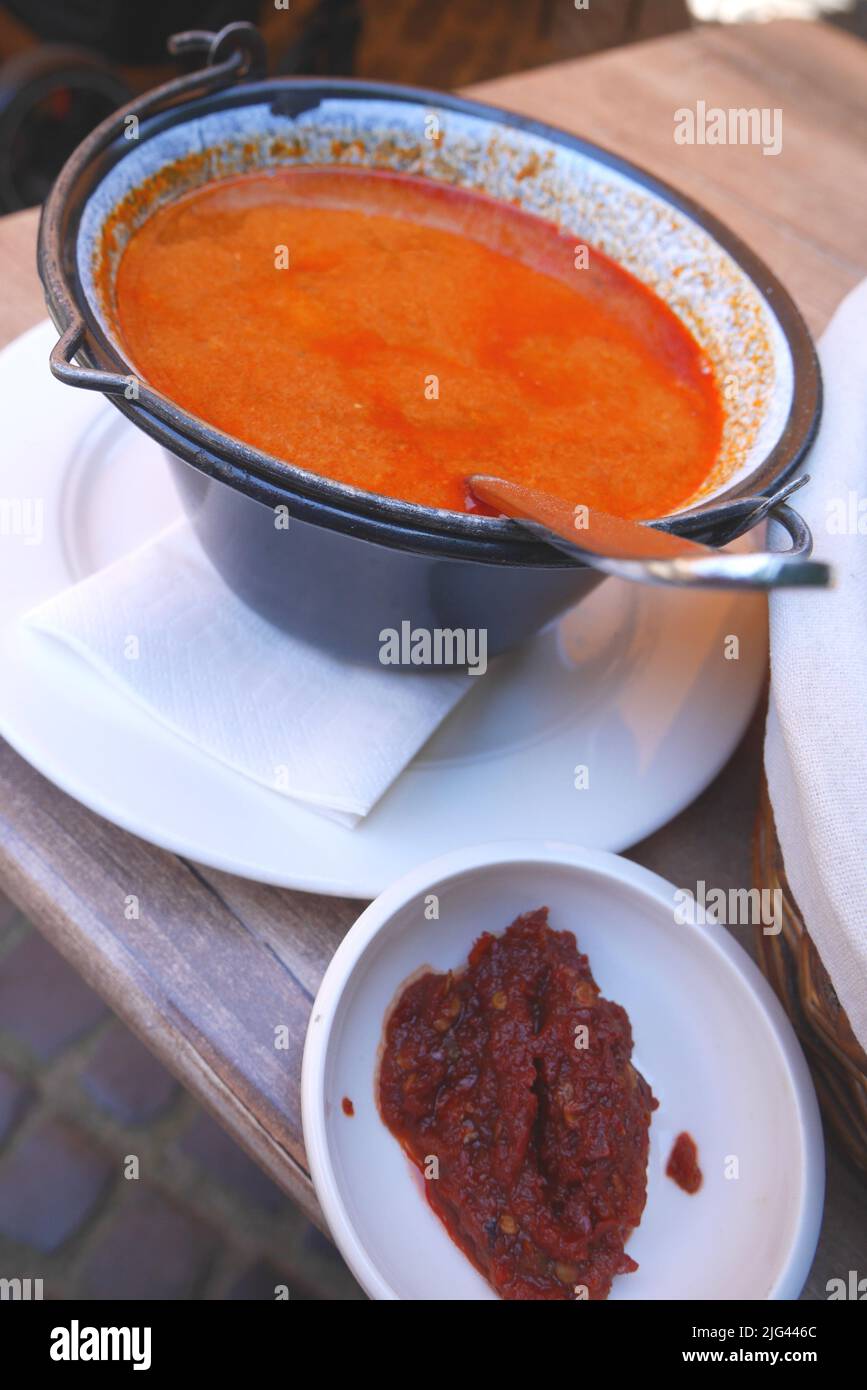 Sopa de pescado tradicional húngara, halaszle, en caldero o bogracs, con pasta de pimentón caliente Foto de stock