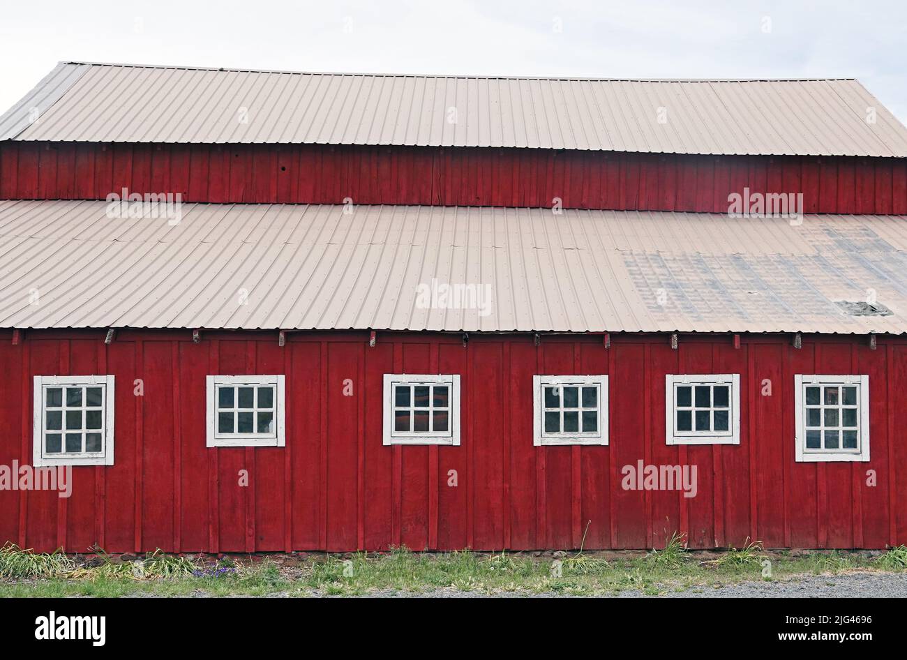 El lado de un viejo granero de madera roja en una granja cerca de Tumalo, Oregon. Foto de stock