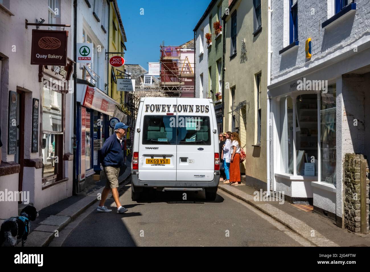 El autobús de la ciudad de Fowey negocia su manera a través de las calles estrechas, Fowey, Cornwall, Reino Unido Foto de stock