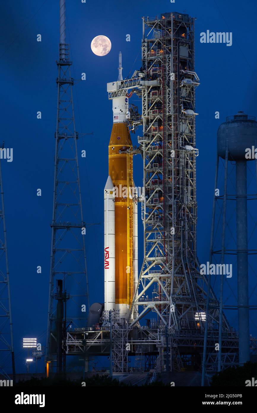 Una luna llena se eleva sobre el cohete del Sistema de Lanzamiento Espacial Artemis I de la NASA con la nave espacial Orion a bordo de un lanzador móvil en el Complejo de Lanzamiento 39B, en el Centro Espacial Kennedy, el 14 de junio de 2022, en Cabo Cañaveral, Florida. El SLS y Orion se están preparando para un ensayo de vestuario húmedo para practicar los plazos y procedimientos para el lanzamiento. Foto de stock