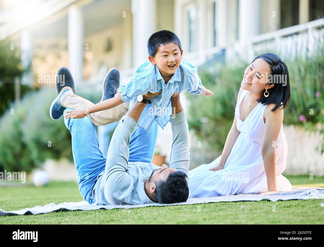 Momentos divertidos, momentos familiares. Foto de una familia joven relajándose en su jardín exterior. Foto de stock