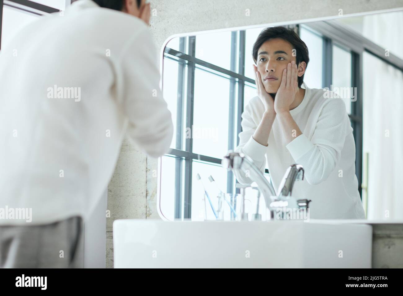 Hombre japonés haciendo el cuidado de la piel Foto de stock