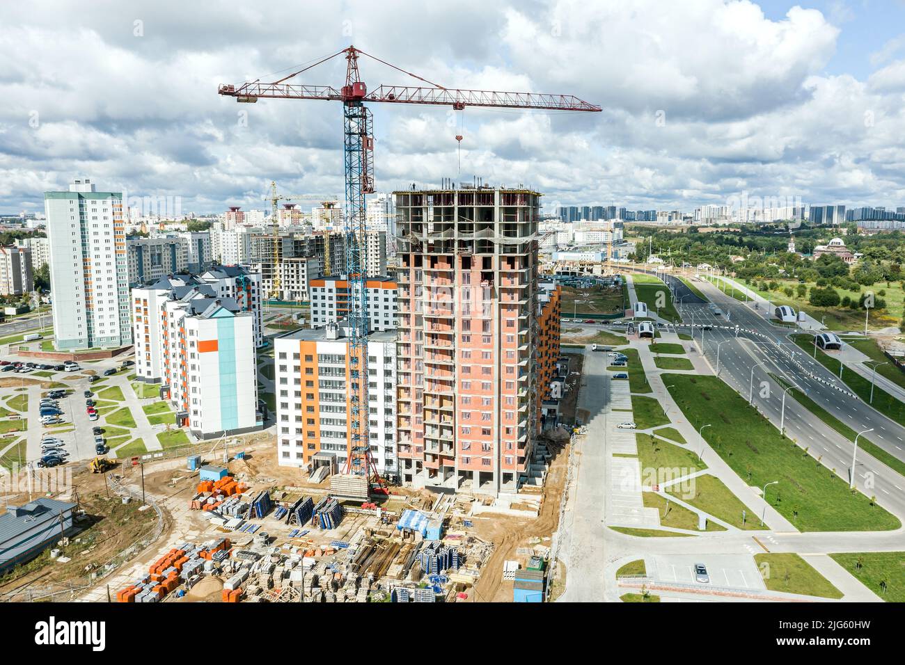 obra de construcción con edificio de apartamentos de gran altura y grúas sobre fondo de cielo nublado. fotografía aérea. Foto de stock