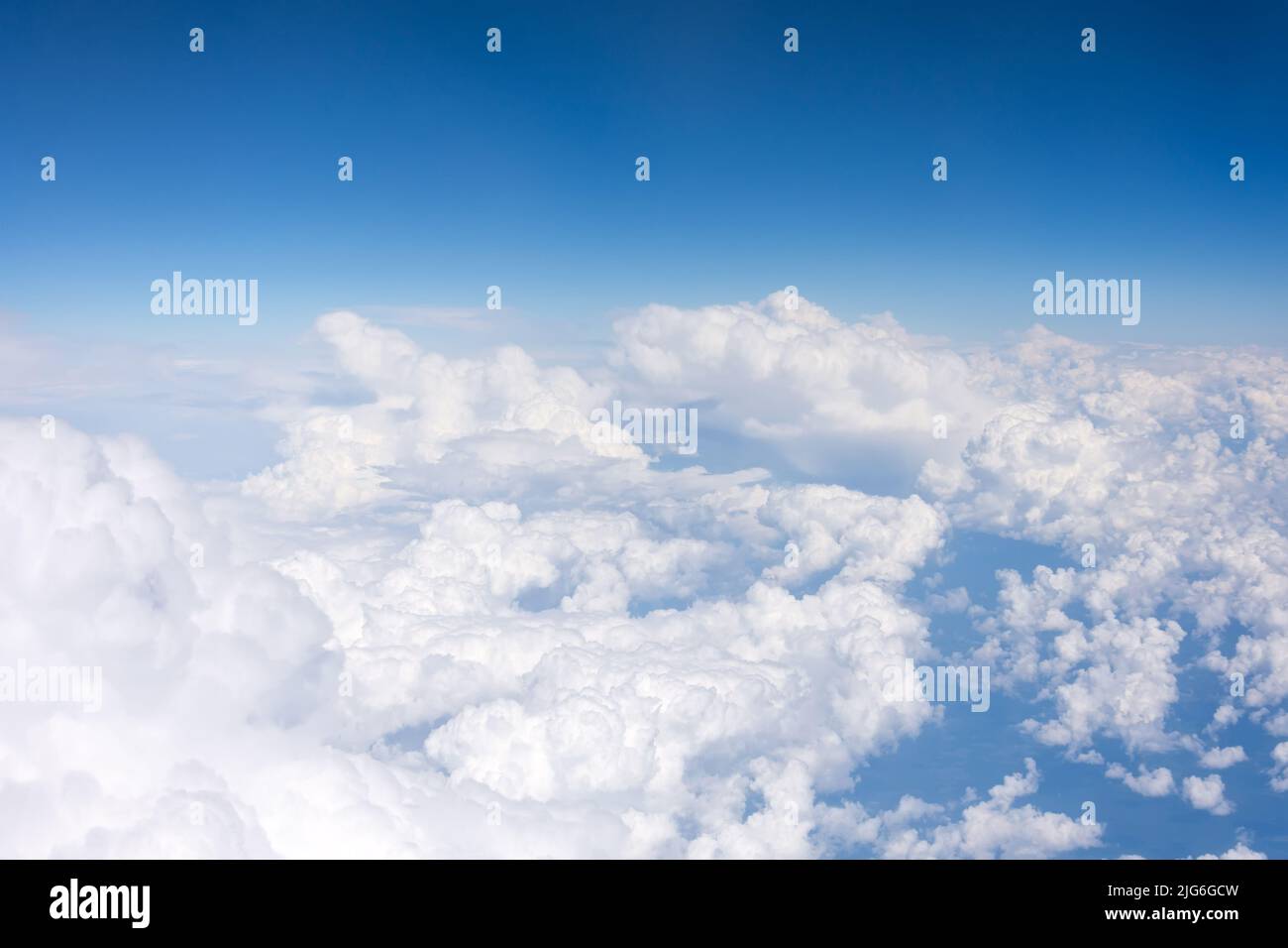 Vista aérea desde arriba a gran altitud de densos cúmulos puffy nubes volando durante el día Foto de stock