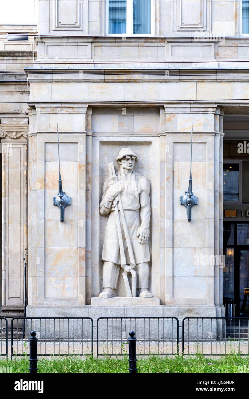 Escultura en bajorrelieve que representa a un representante de la clase obrera en la fachada de un edificio en la Plaza de la Constitución, Varsovia, Polonia Foto de stock