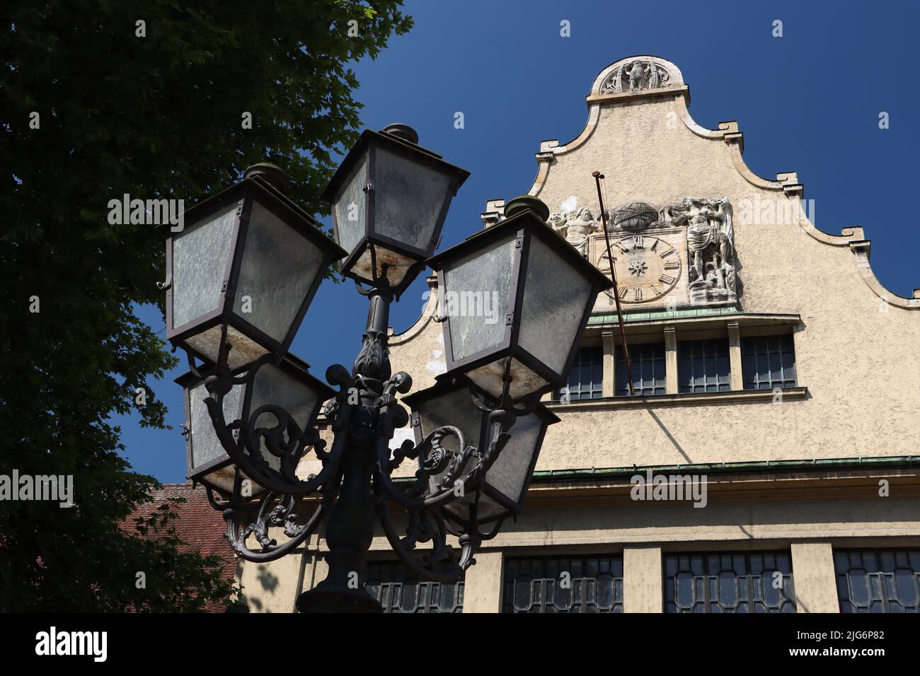 la antigua farola contiene cinco lámparas separadas para iluminar la noche.  foto tomada en bavaria, lindau con el cielo azul frente a un edificio  histórico Fotografía de stock - Alamy