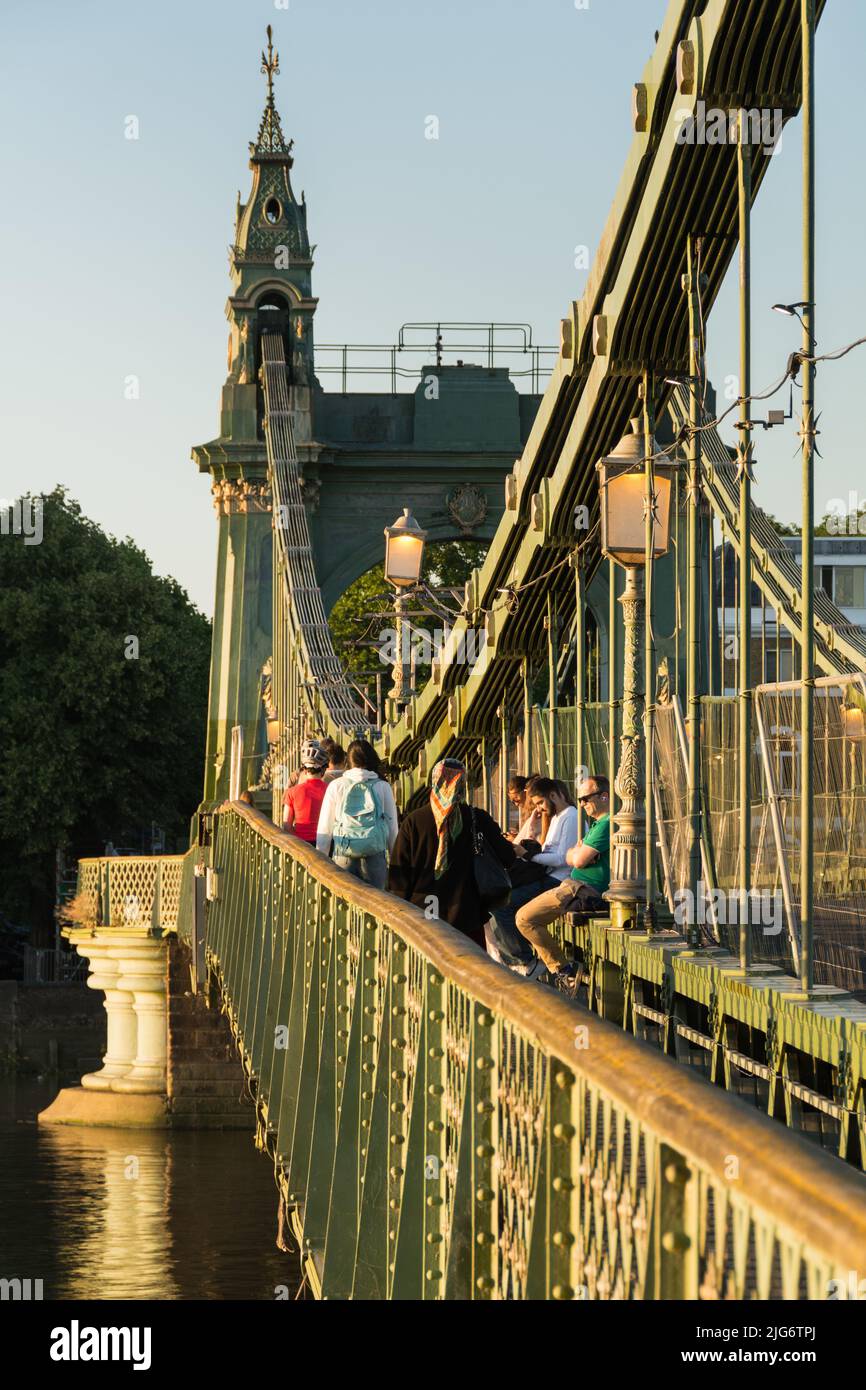 Peatones cruzando el puente colgante Hammersmith en el oeste de Londres, Inglaterra, Reino Unido Foto de stock