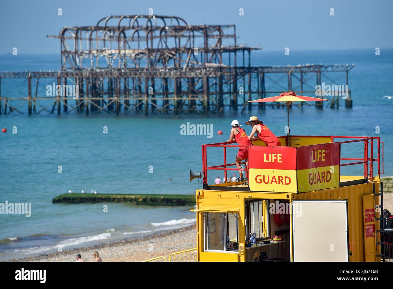 Brighton Reino Unido 8th de julio de 2022 - Los salvavidas miran hacia fuera sobre la playa de Brighton en el sol caliente como una posible ola de calor se pronostica para partes del Reino Unido durante la semana próxima. : Crédito Simon Dack / Alamy Live News Foto de stock