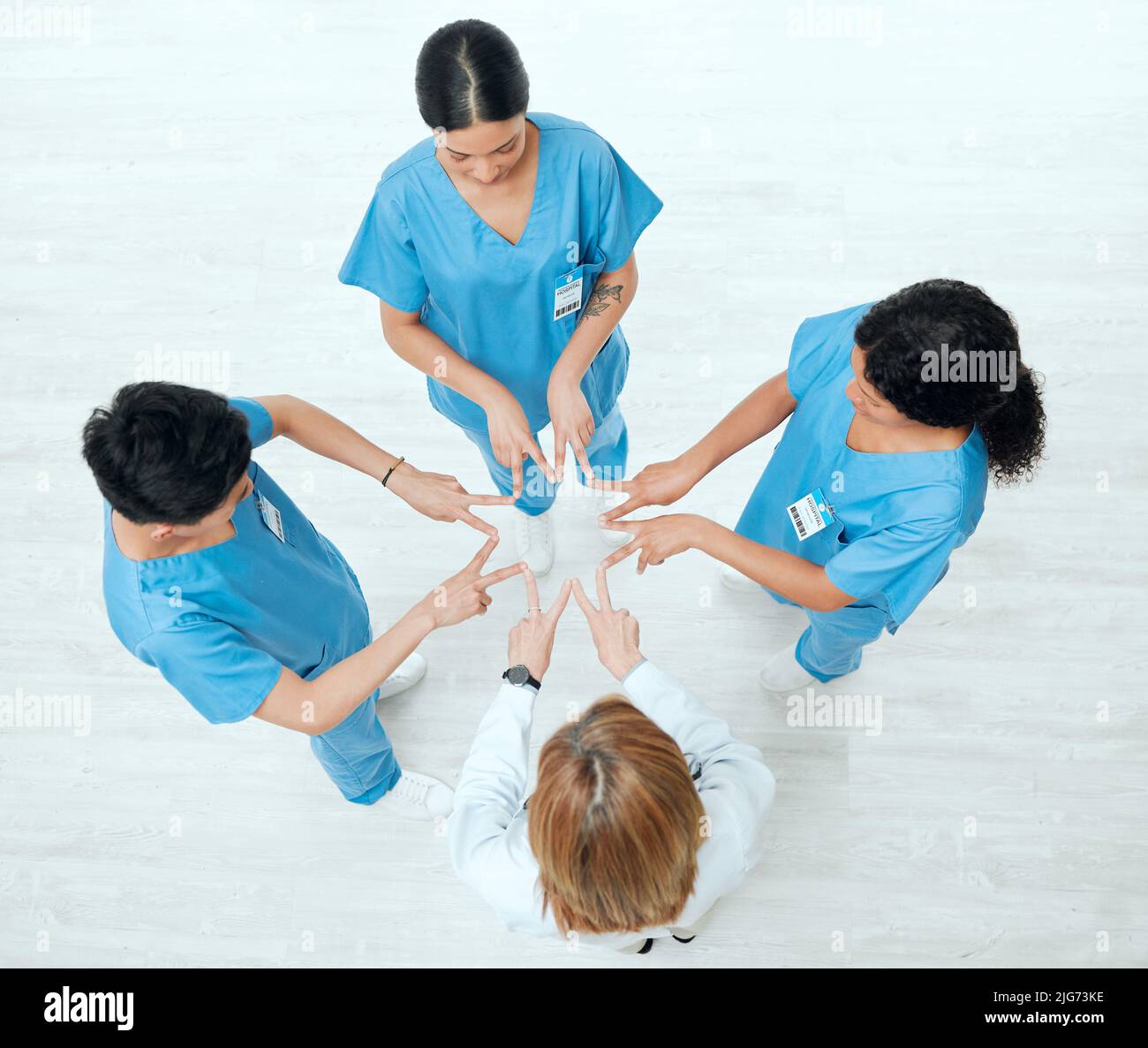 Observar las estrellas de un tipo diferente. Foto de arriba de un grupo de médicos que unen sus manos en forma de estrella en un hospital. Foto de stock