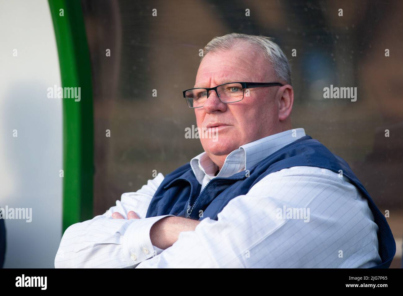 Primer plano de Steve Evans, director del Stevenage FC, sentado en el dugout Foto de stock