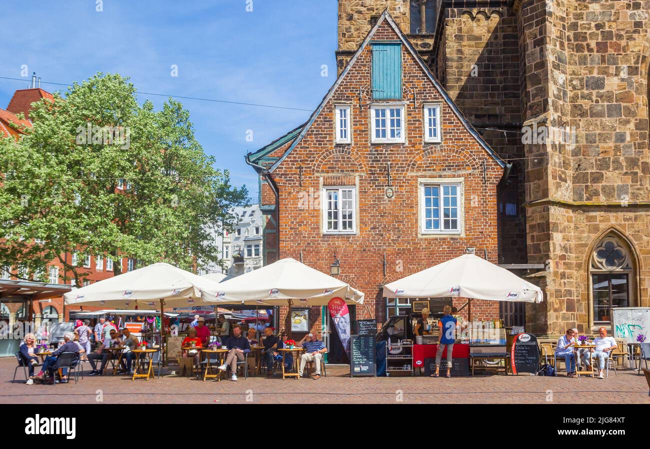 Gente en un café frente a la iglesia Liebfrauenkirche en Bremen, Alemania Foto de stock