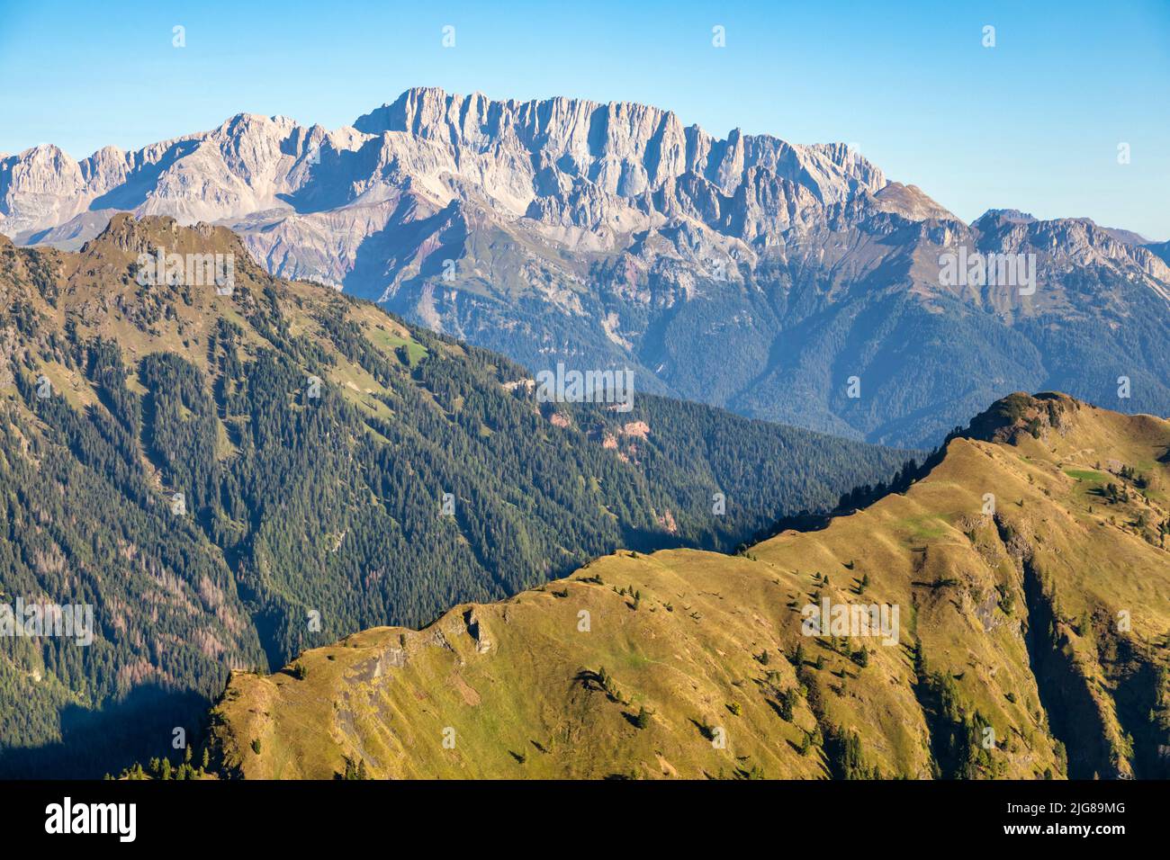 Italia, Veneto, Belluno, Canale d'Agordo, vista por la mañana de la cresta verde de Palalada, al fondo el lado del siuth de Marmolada Foto de stock