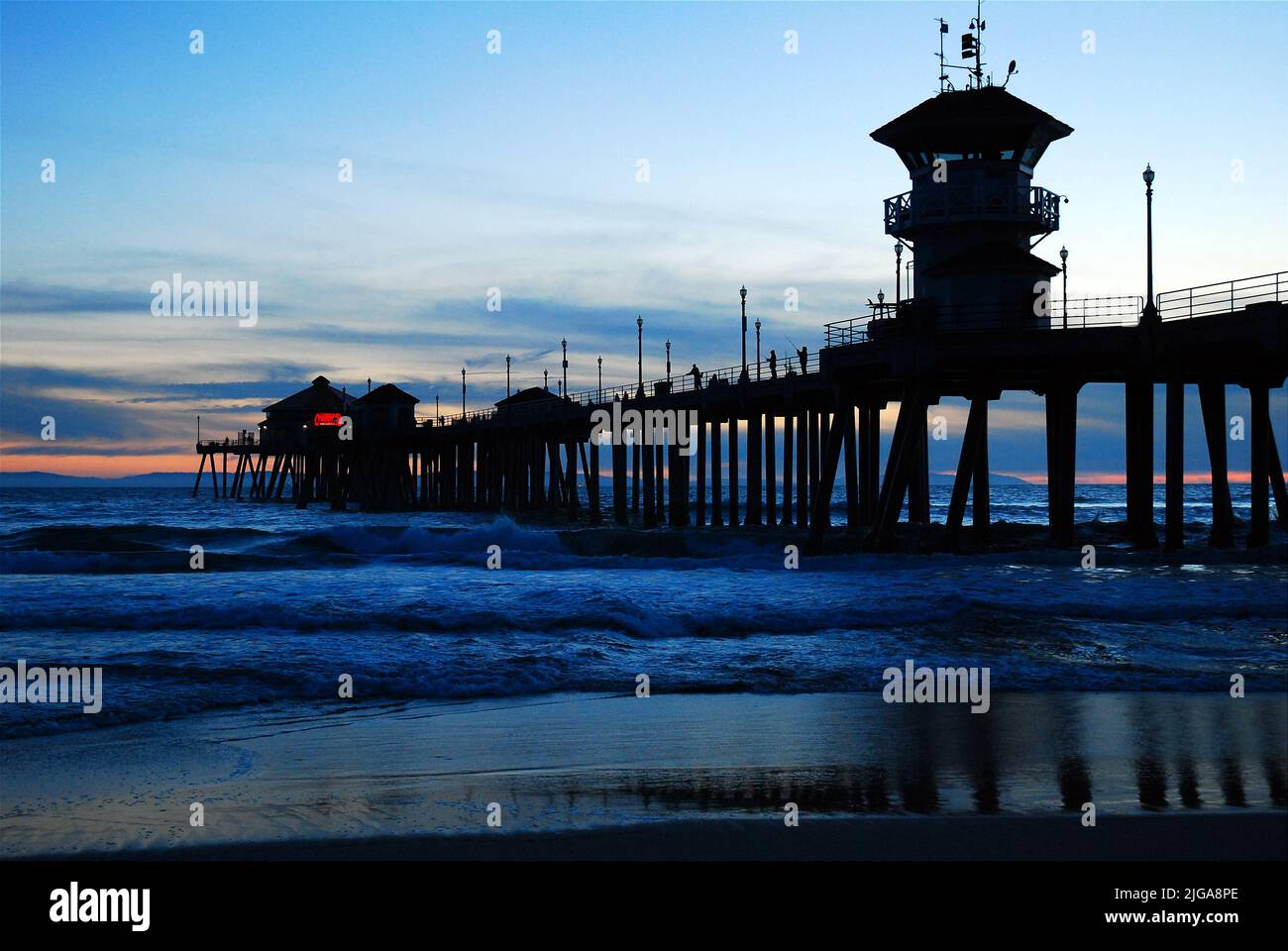 Las olas se meten en la orilla del muelle de Huntington Beach durante