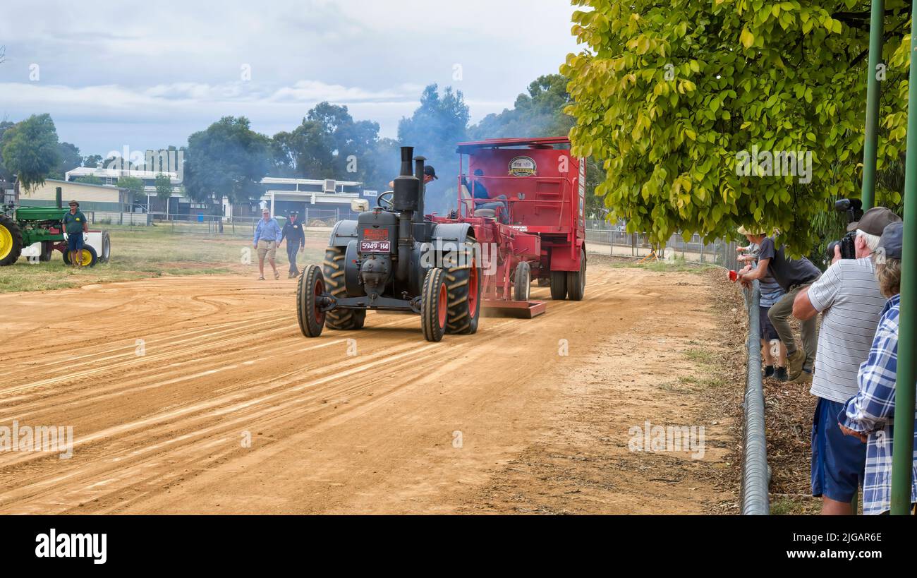 Yarrawonga, Victoria, Australia - 3 de abril de 2022: Mucho humo mientras el gran tractor negro tira del trineo en el recinto ferial Yarrawonga Showgrounds Foto de stock