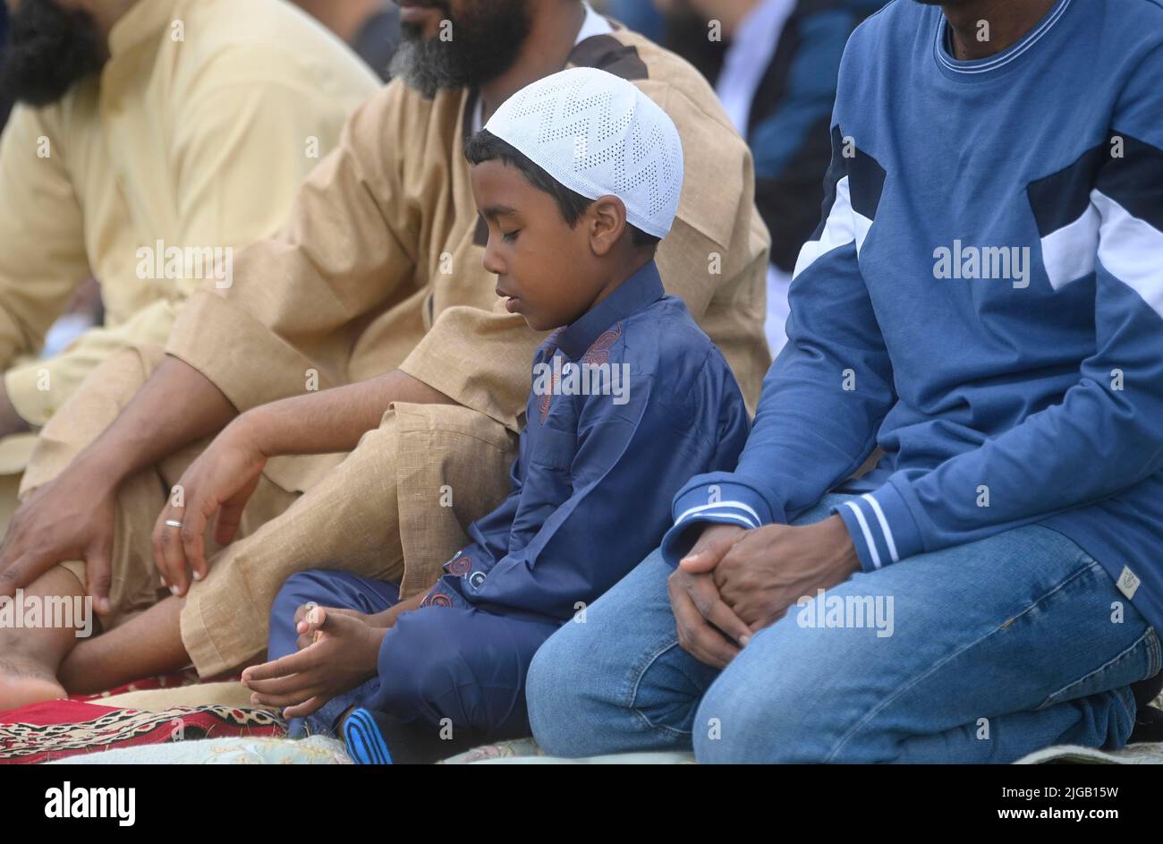 Un niño ora durante el festival Eid en los terrenos de Davitt Park GAA en Belfast. El festival Eid es un día importante en el calendario musulmán cuando la comida se comparte con parientes, amigos y pobres. Fecha de la foto: Sábado 9 de julio de 2022. Foto de stock