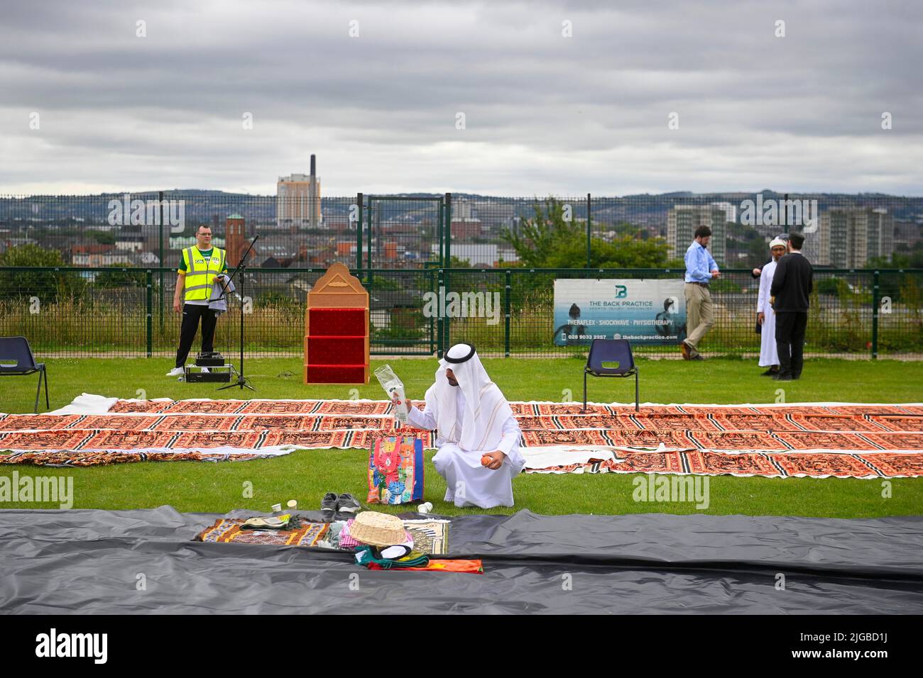 Un hombre reúne su pertenencia después del festival Eid en los terrenos de Davitt Park GAA en Belfast. El festival Eid es un día importante en el calendario musulmán cuando la comida se comparte con parientes, amigos y pobres. Fecha de la foto: Sábado 9 de julio de 2022. Foto de stock