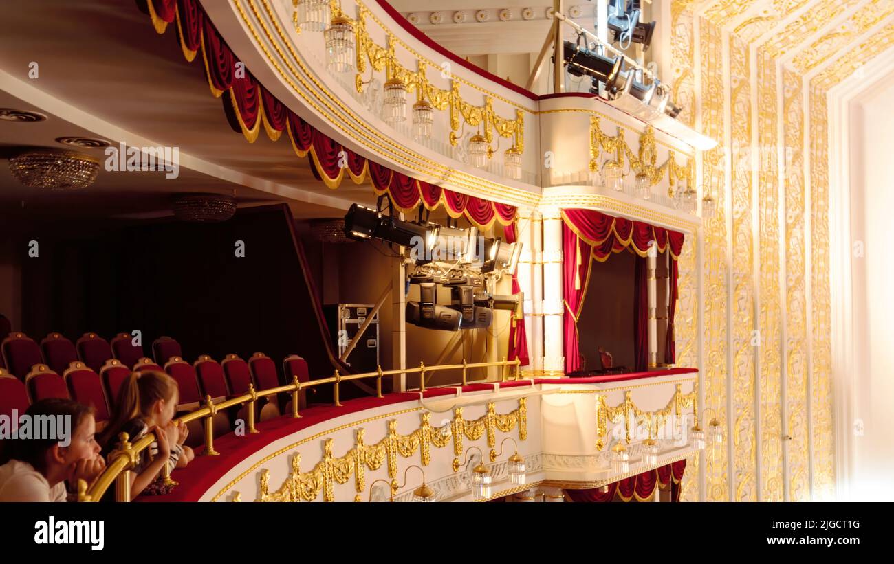 Hermoso interior clásico de balcón con estuco dorado en el teatro de ópera y ballets. Accesorios de iluminación para destacar un concierto musical en Foto de stock