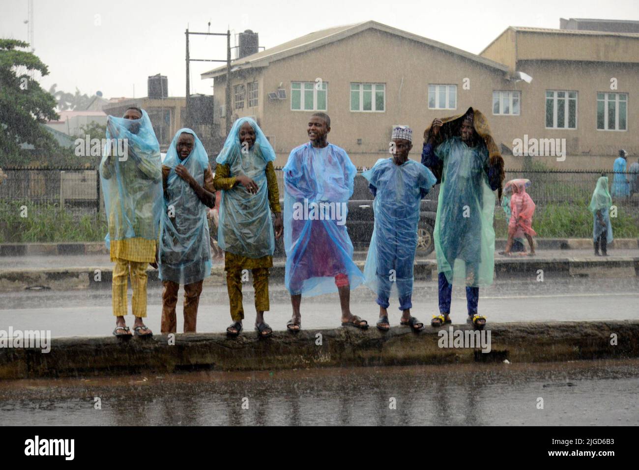 Lagos, Nigeria, 9th de julio de 2022 Los hombres esperan para cruzar la carretera Como fieles musulmanes, a pesar de las fuertes lluvias, oren para celebrar el festival Eid-el-Kabir 2022 en Ikeja, a lo largo de Lagos, Nigeria, el sábado 9 de julio de 2022. Foto de Adekunle Ajayi Crédito: Adekunle Ajayi/Alamy Live News Foto de stock