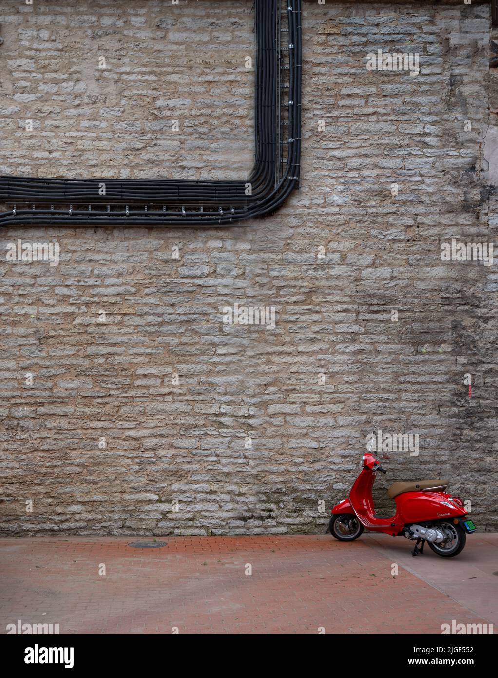 Tallin, Estonia. Julio 2022. El scooter rojo estacionado en la ciudad Foto de stock