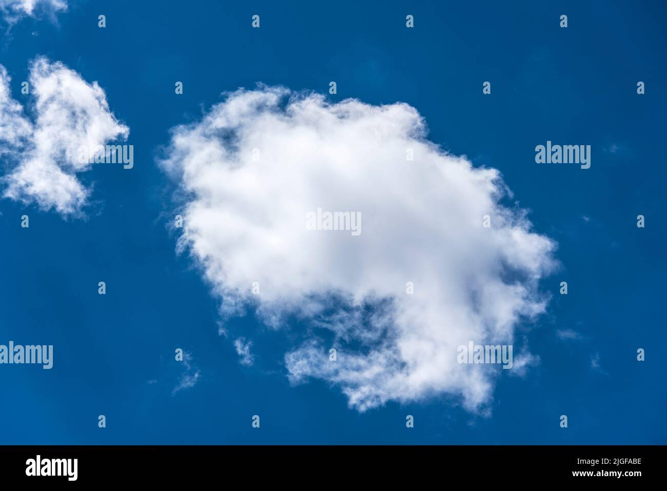 esponjosas nubes blancas de estratocúmulos en un claro cielo azul profundo en un día de verano Foto de stock