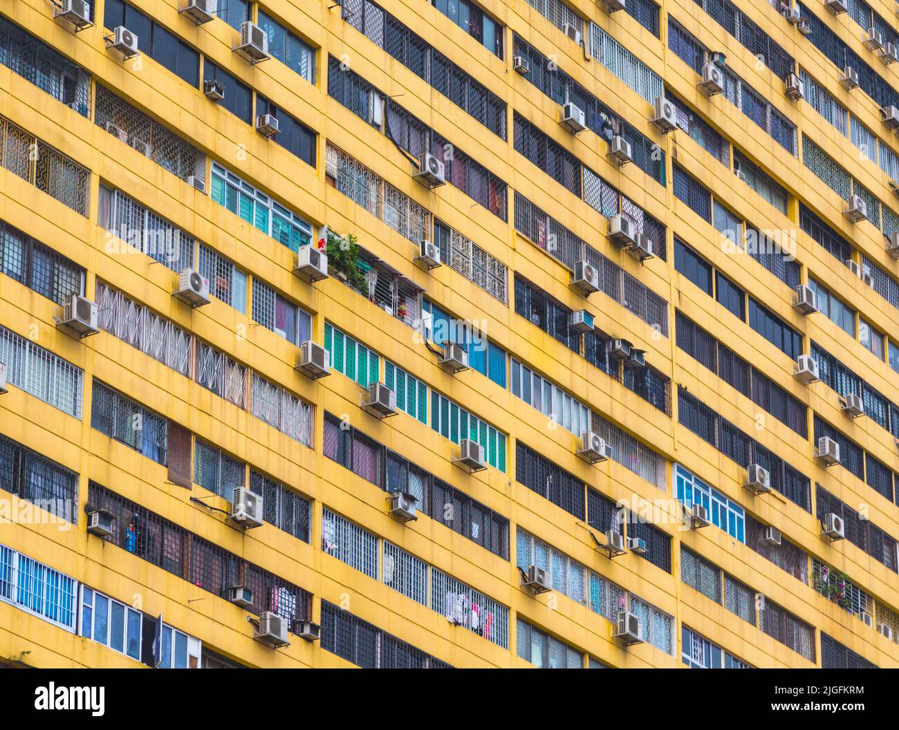 Múltiples unidades de aire acondicionado en el exterior del edificio de apartamentos, República de Singapur. Los acondicionadores de aire emiten gases de efecto invernadero conocidos como hidrofluoro Foto de stock