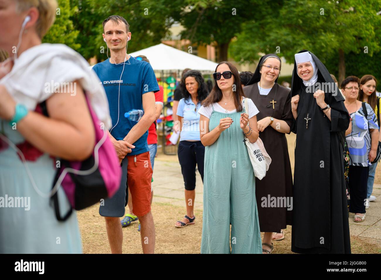 Dos monjas sonrientes, entre otros peregrinos, de pie en fila para escribir una oración durante el Mladifest 2021 – el festival de la juventud – en Medjugorje. Foto de stock