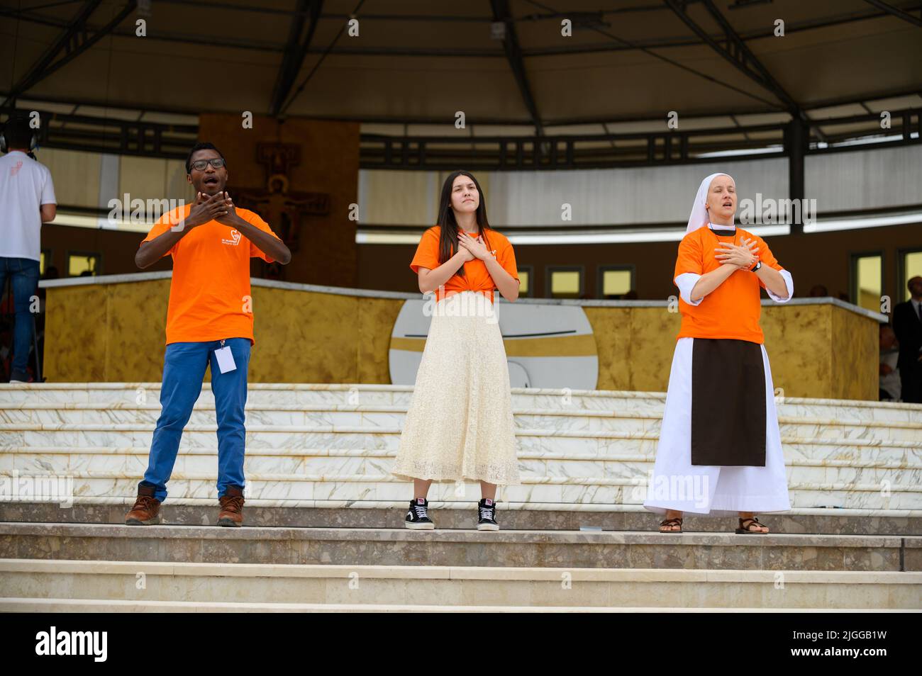 Voluntarios mostrando movimientos de manos y cuerpos para canciones cristianas en Mladifest 2021, el festival juvenil, en Medjugorje. Foto de stock