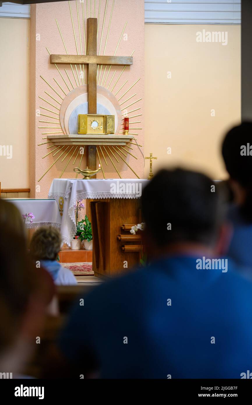 El Santísimo Sacramento expuesto para la adoración en la capilla de adoración de Medjugorje. La gente está orando en postración. Foto de stock