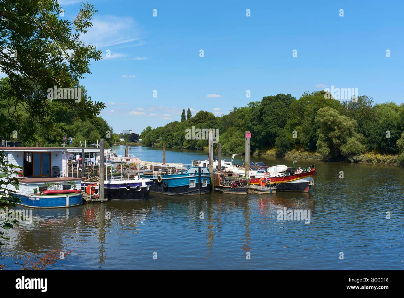 El río Támesis entre Isleworth y Richmond Lock, al oeste de Londres, Reino Unido, con casas flotantes y barcazas Foto de stock
