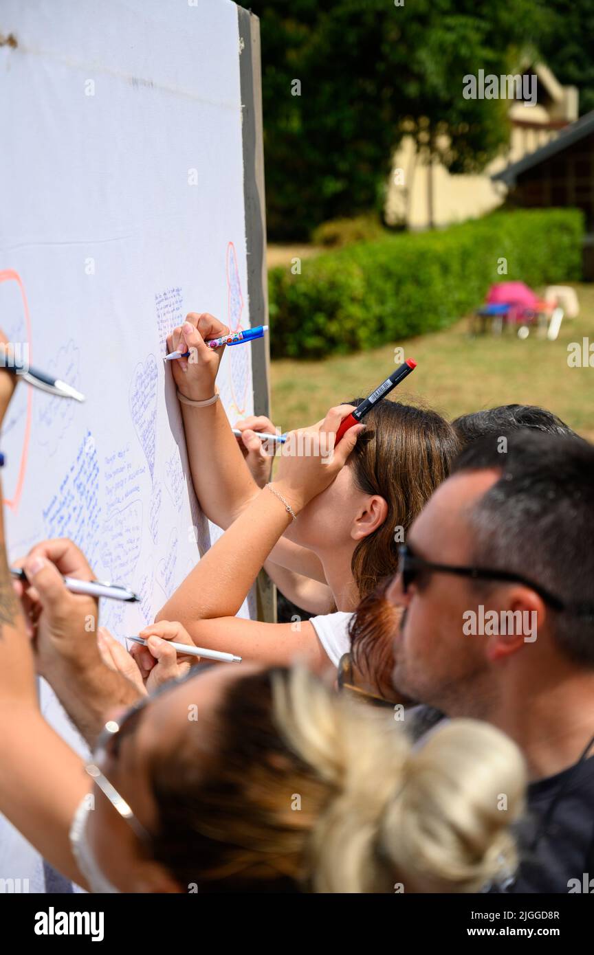 Jóvenes escribiendo sus oraciones en un largo rollo de hojas durante el festival de la juventud de Mladifest 2021 en Medjugorje. Foto de stock