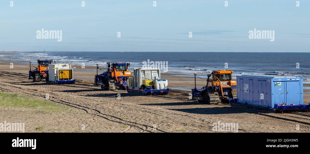 El equipo de reabastecimiento de arena se está moviendo en la playa Foto de stock
