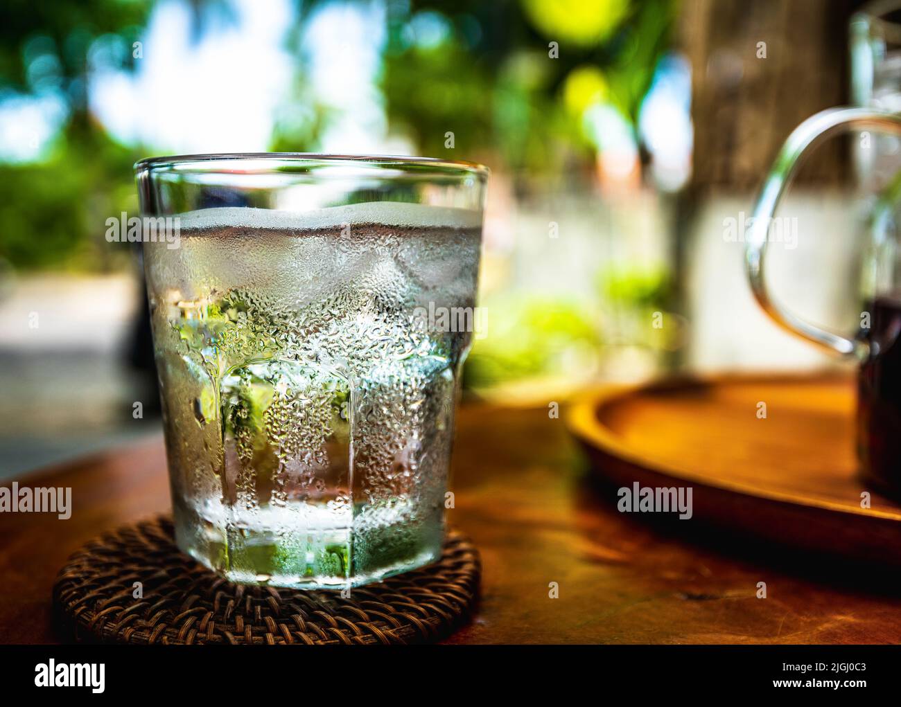 Agua fría sobre un vaso de agua transparente con hielo y condensación a