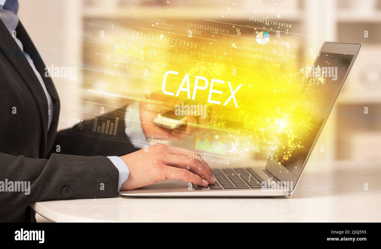 Cierre de manos de hombre de negocios trabajando en el portátil con inscripción CAPEX, concepto de negocio exitoso Foto de stock