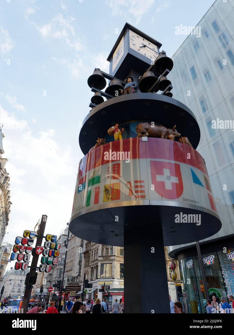 Londres, Gran Londres, Inglaterra, Junio 15 2022: Reloj suizo de glockenspiel en Leicester Square con la bandera de Cantón atrás. Foto de stock