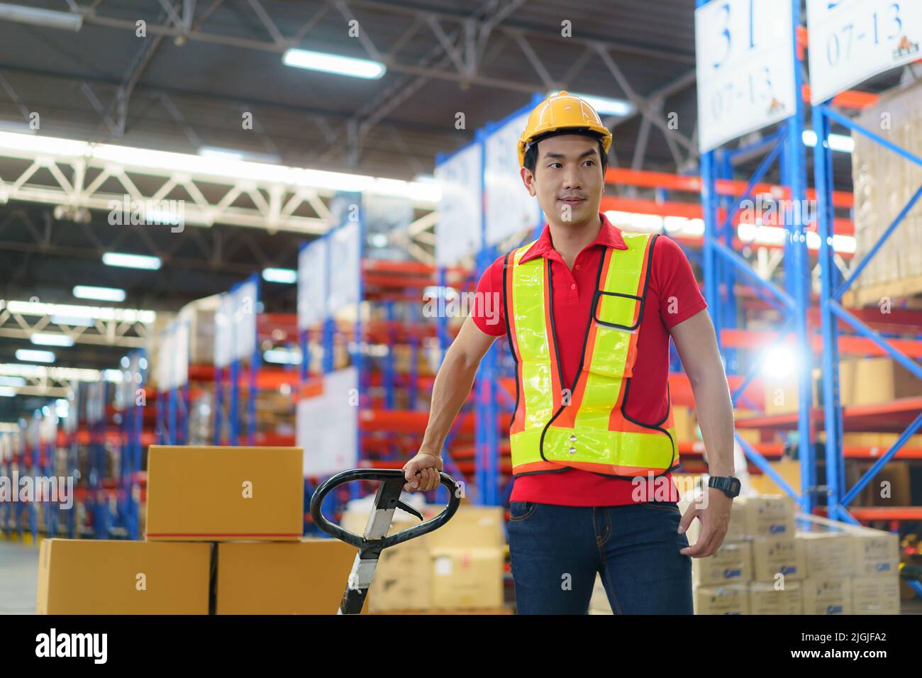 Cajas de envío. Hombre asiático Trabajador de almacén descargando mercancías de envío de palet en un contenedor de camión, carga de la industria de almacén, logística y transporte Foto de stock
